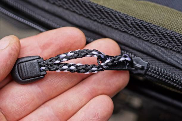 istock fingers hold a black metal zip with a drawstring 1316668462