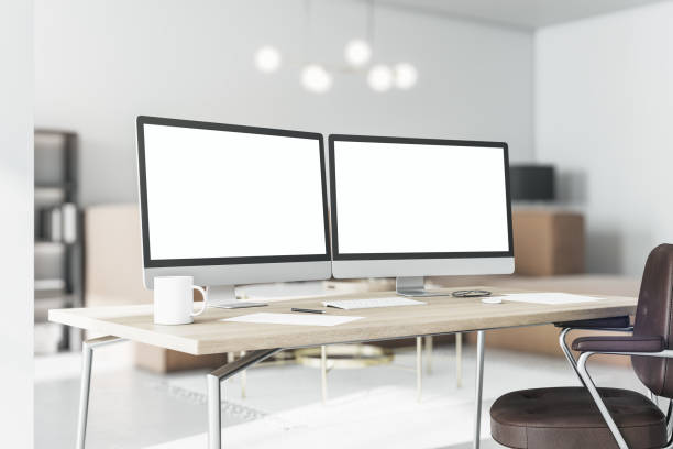 istock Blank white computer monitors on light wooden table with modern keyboard and coffee mug in stylish home office. 3D rendering, mockup 1316669580