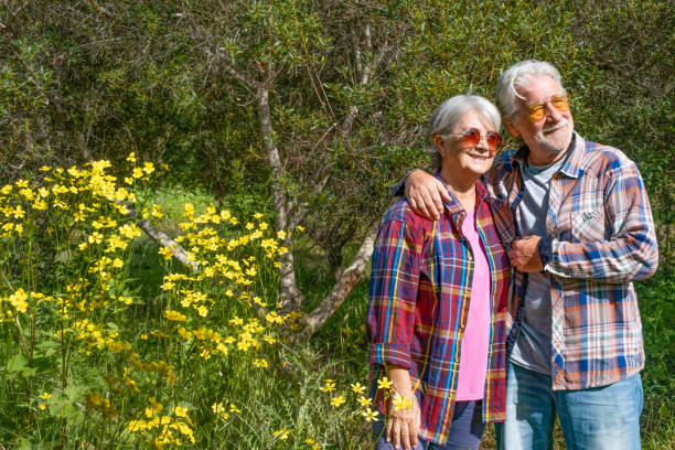 istock Smiling elderly couple in forest enjoying springtime and blossom. Trees and meadow 1316669615