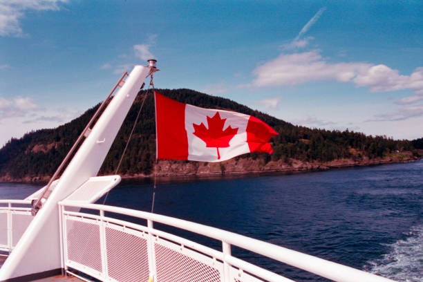 drapeau du canada agitant depuis un bateau près de l’île de vancouver - ferry terminal photos et images de collection