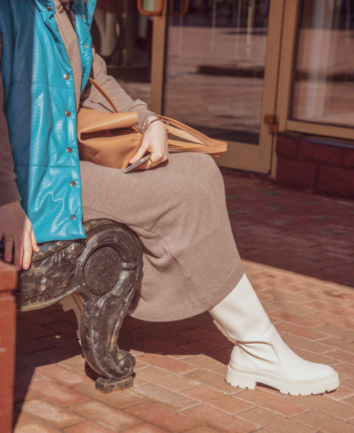 istock A girl in white leather boots sits on a bench . 1316672056