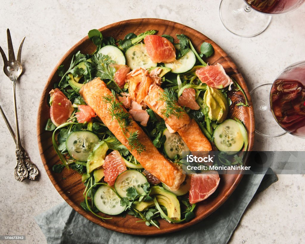 Salmon over watercress salad Flat lay of Two slices of Salmon over watercress salad. Salmon - Seafood Stock Photo