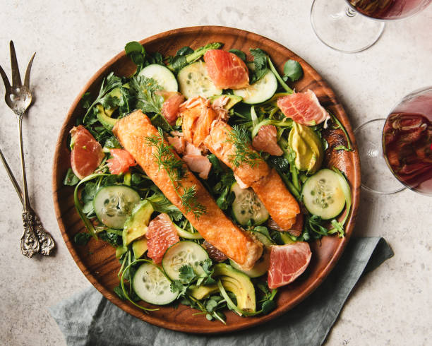 Salmon over watercress salad Flat lay of Two slices of Salmon over watercress salad. salad dressing photos stock pictures, royalty-free photos & images