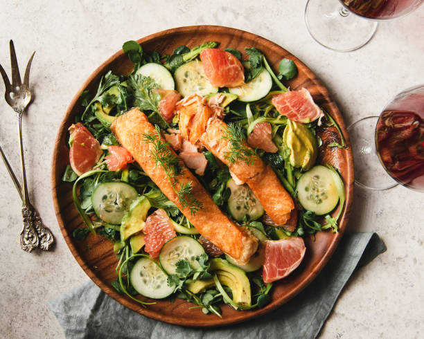 Salmon over watercress salad Flat lay of Two slices of Salmon over watercress salad. salmon stock pictures, royalty-free photos & images