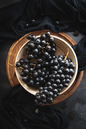 Flat lay of still life of Black grapes on bowl