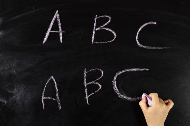 istock child hand writes on the blackboard abc 1316674584