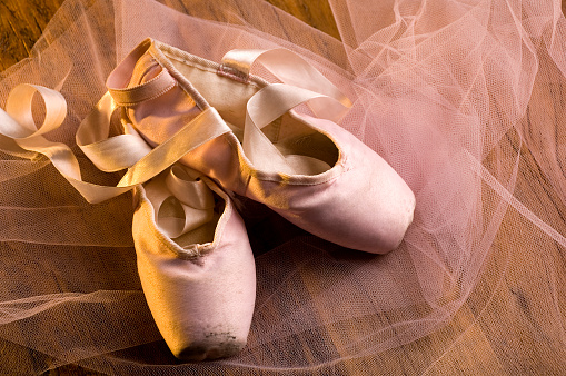 Pointe shoes ballerinas and flowers on a pink background