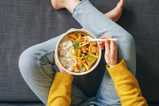 Woman eating rice with tofu for lunch