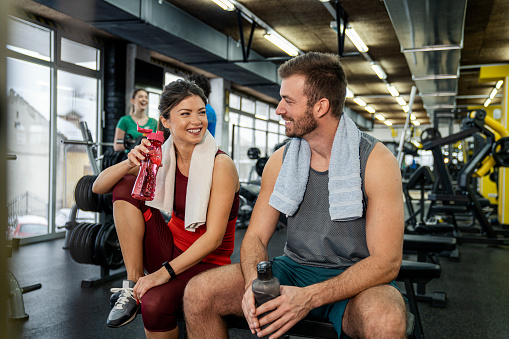 Couple taking a break after workout at gym