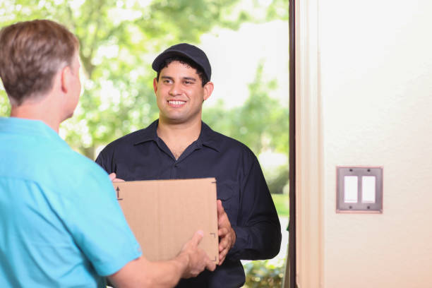 istock Latin descent delivery man with box arrives at customer home. 1316679234