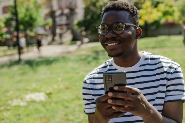 istock African-American young man is using mobile phone in the park 1316681405