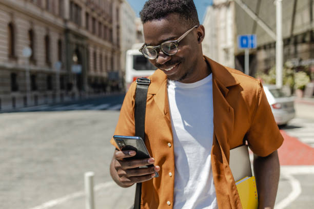 istock African-American confident young man is using mobile phone on the street 1316681527