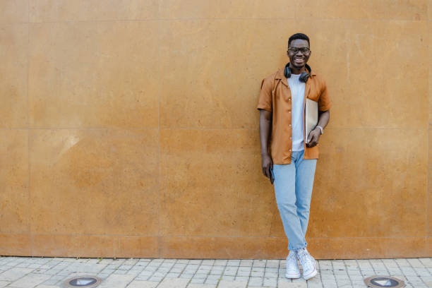 istock Smiling young man is standing in front of the orange wall 1316681566
