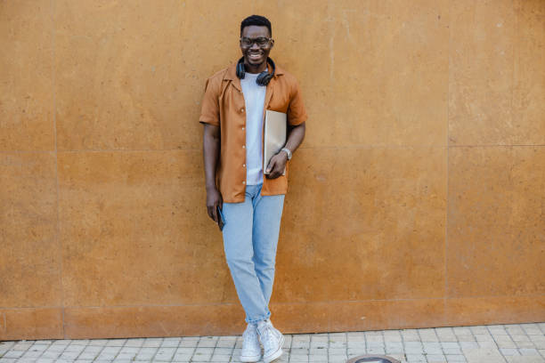 istock Smiling young man is standing in front of the orange wall 1316681729