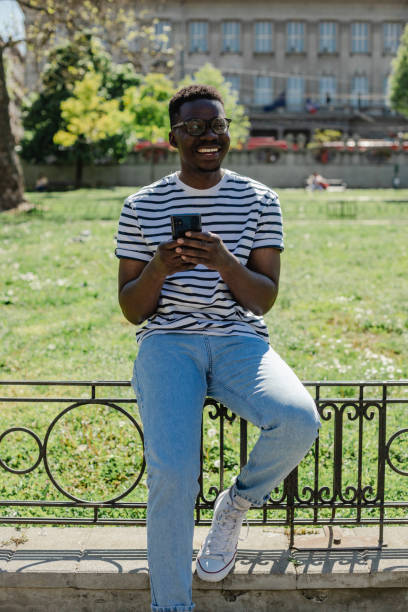 istock African-American young man is using mobile phone in the park 1316681753