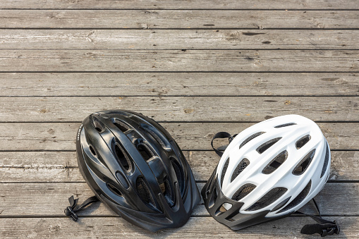 Close up view of two helmets for active sports on wooden background isolated. Sweden.