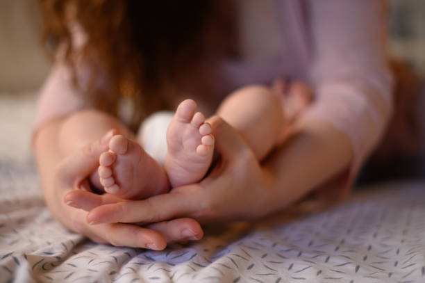 istock Mother hands holding a tiny baby feet 1316685921