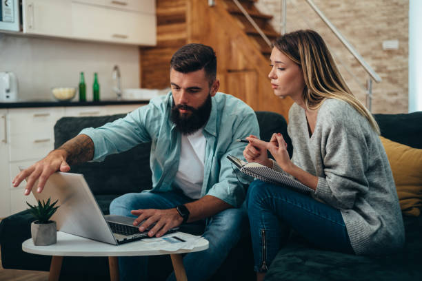 istock Couple using a laptop for paying bills online together at home 1316685934
