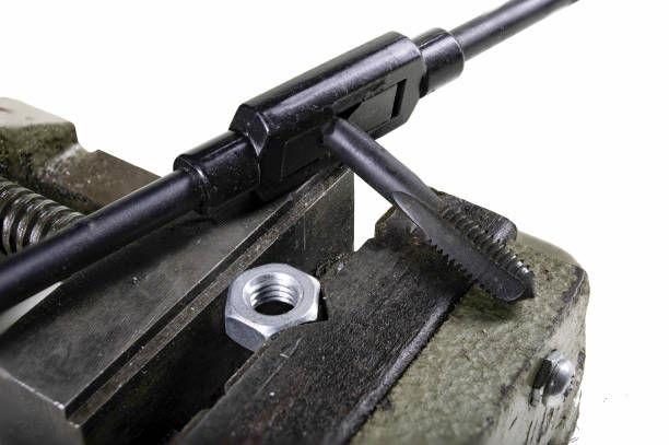 istock The screw nut in a vice while cutting a mechanical thread. Minor locksmith work in the workshop. Isolated background. 1316687359