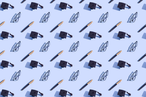 istock Graduate cap, glasses and pen pattern on blue background with hard shadow. Education background 1316689336