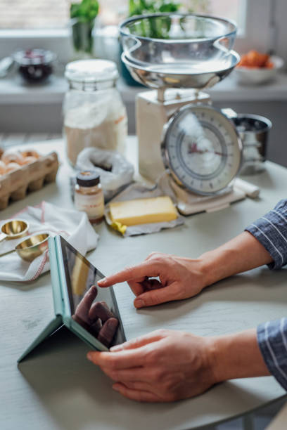 istock Home Baker: a Anonymous Woman Reading a Recipe on Her Digital Tablet 1316690006