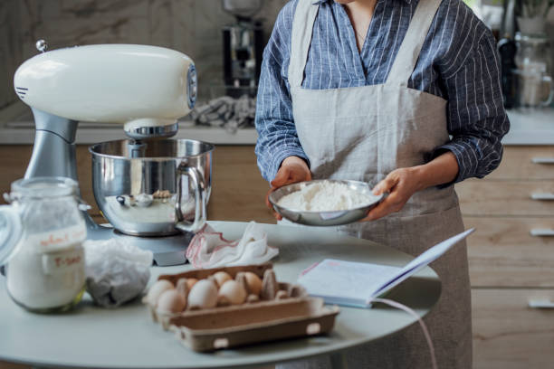 istock Anonymus Woman Adding Flour to the Mixing Bowl 1316690057