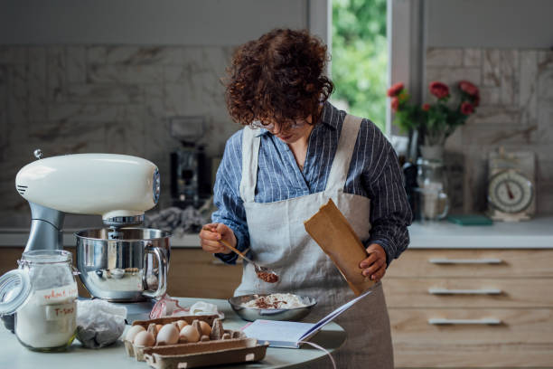 istock Making Chocolate Chip Cookies: Woman Adding Cocoa to the Flour Mixture 1316690110