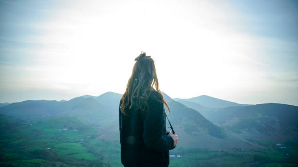 istock Female photographer walks through grassy meadow 1316693269