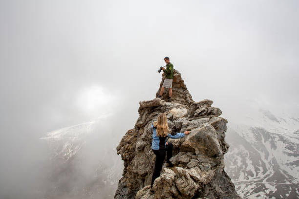 istock Hikers relax on rock pinnacle and take photos on camera 1316695006