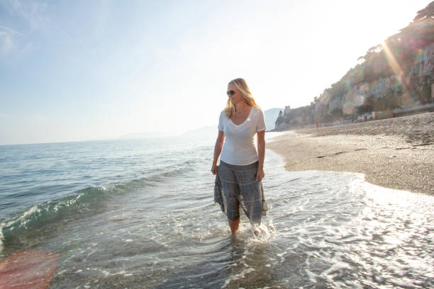 istock Woman walks along Mediterranean beach at sunrise 1316695028