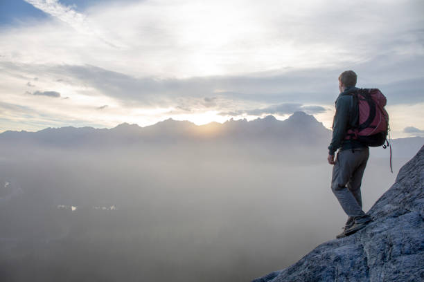 istock Hiker relaxes on mountain ridge at sunrise 1316695066