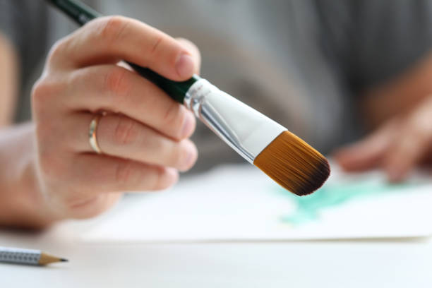 istock Male hand making drawing with watercolor brush 1316695653
