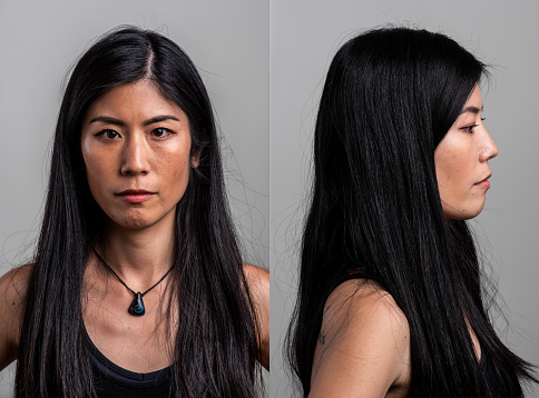 Serious asian mid adult woman front and profile mugshots on gray background
