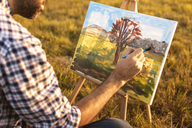 istock Young man painting in nature on canvas at sunset 1316699028