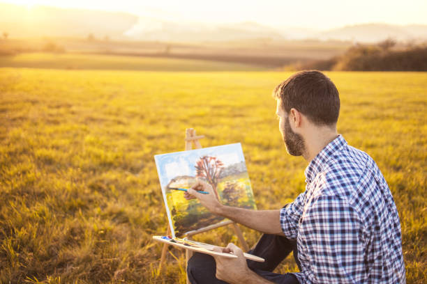 istock Young man painting in nature on canvas at sunset 1316699039