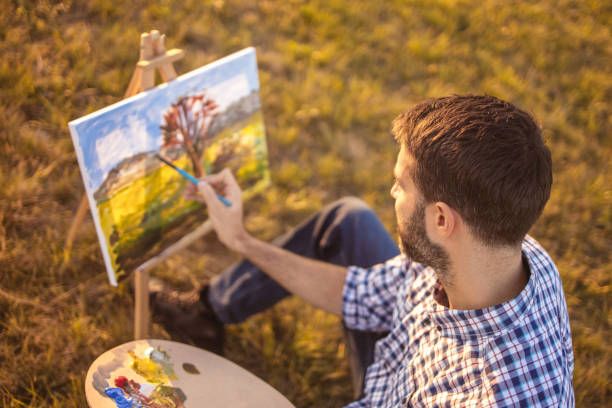 istock Young man painting in nature on canvas at sunset 1316699051