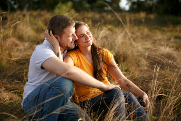 istock Young couple in love sitting on the grass 1316701390