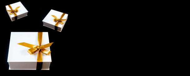istock White gift boxes tied with yellow ribbon on black 1316703141
