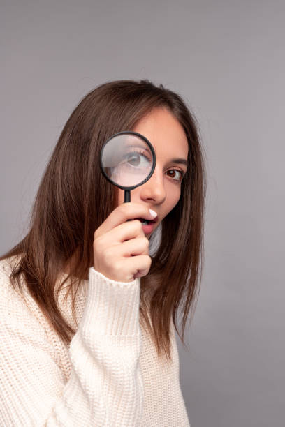 istock Curious woman looking through magnifying glass 1316709649