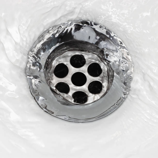 istock Sink plug drain hole bath plughole, white basin spout, running water macro closeup, stainless steel, china porcelain hand washbasin, large detailed bright horizontal wash-hand swirl flat lay detail, environment saving bathroom concept 1316712450
