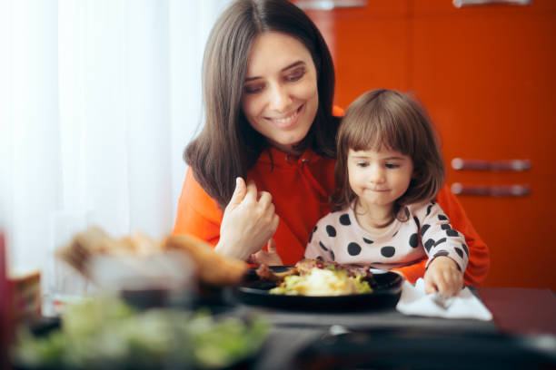 istock Mother and Daughter Sitting Together at Dinner Table 1316715002