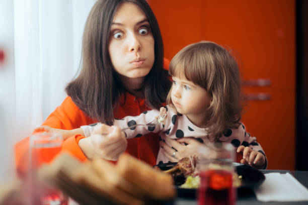 istock Hungry Mom Trying to Eat While Child Sits on her Lap 1316715006