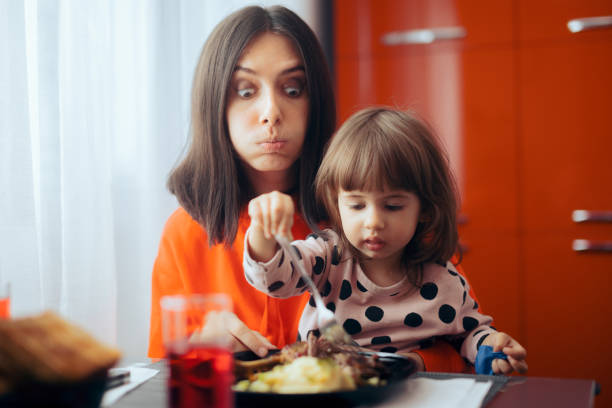 istock Self-Feeding Independent Toddler Sitting with Mom Eating with Fork 1316715010