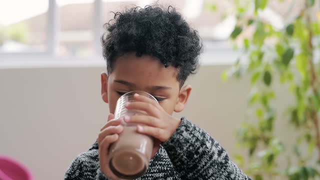 4k video footage of an adorable little boy having a chocolate milkshake at home