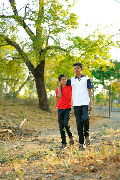 istock two little indian brother walking on road 1316728058