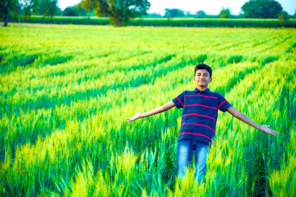 indian cute little boy spreading his arms at field
