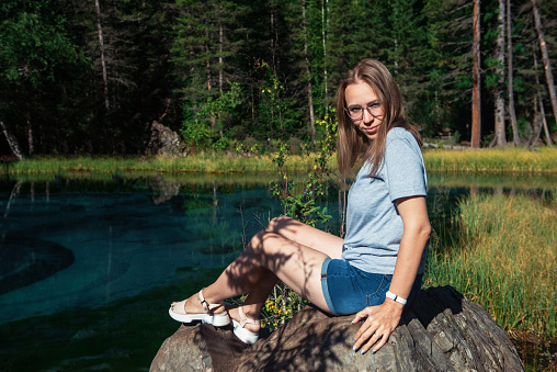 Woman resting at mountain lake in summer, Altai mountains