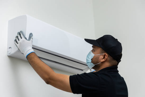 istock Air conditioner service indoors. Air conditioner cleaning technician He opened the front cover and took out the filters and washed it. He in uniform wearing rubber and mask. 1316731249