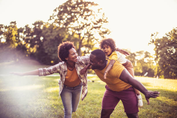 афроамериканская семья весело провести время на открытом воздухе. - family happiness outdoors autumn стоковые фото и изображения