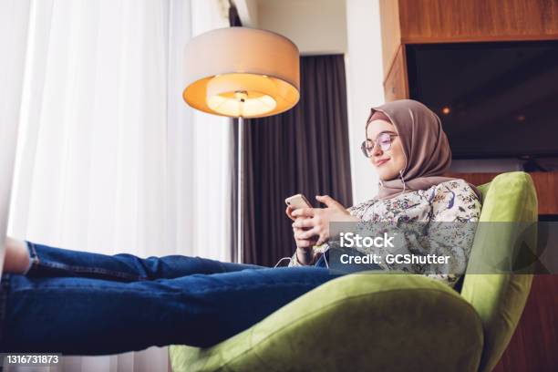 Middle Eastern Girl Listening To Music Using Smartphone Stock Photo - Download Image Now